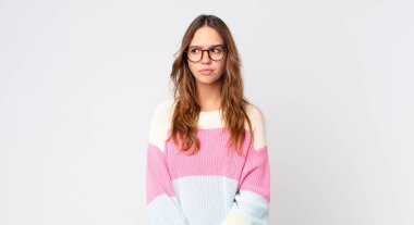 Genç, güzel bir kadın üzgün, üzgün ya da kızgın hissediyor ve yan tarafa bakıyor.