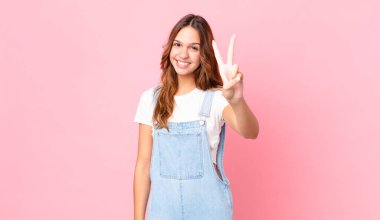 Genç, güzel bir bayan gülümsüyor ve arkadaş canlısı görünüyor.