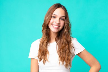 Genç ve güzel bir kadın mutlu bir şekilde gülümsüyor.