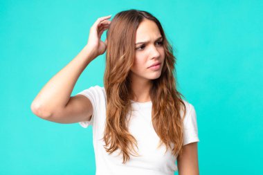 Kafası karışmış, kafası karışmış, kaşınan genç bir kadın.