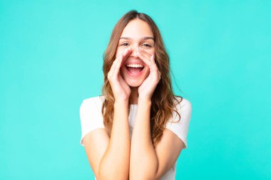 Genç, güzel bir kadın kendini mutlu hissediyor. Elleri ağızda bağırıyor.