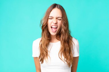 Genç ve güzel bir kadın agresif bir şekilde bağırıyor, çok kızgın görünüyor.