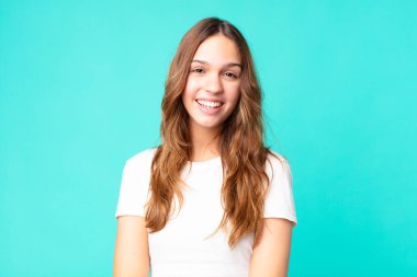 Genç ve güzel bir kadın mutlu ve hoş bir şekilde şaşırmış görünüyor.