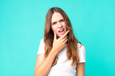 Ağzı ve gözleri açık, eli çenesinde genç ve güzel bir kadın.