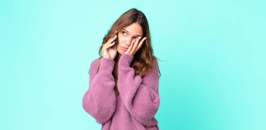 Genç ve güzel bir kadın bıkkın, yorgun ve uykulu hissediyor ve akıllı telefon kullanıyor.