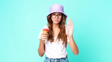 Genç ve güzel bir kadın ciddi görünüyor. Elinde dondurma tutmaktan vazgeçiyor. yaz konsepti