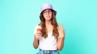 Genç, güzel bir kadın kendini stresli, endişeli, yorgun ve elinde dondurma tutarken hayal kırıklığına uğramış hissediyor. yaz konsepti