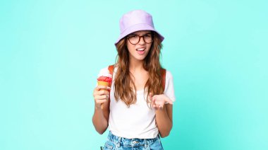 Genç ve güzel bir kadın elinde dondurma tutarken sinirli, sinirli ve sinirli görünüyor. yaz konsepti