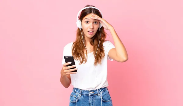 Fiatal Csinos Néz Boldog Meglepett Meglepett Fülhallgató Egy Okostelefon — Stock Fotó