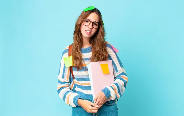 Jovem Bonita Mulher Sentindo Intrigado Confundido Com Saco Segurando Livros — Fotografia de Stock