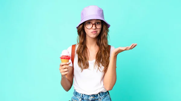 若い女性は戸惑って混乱してアイスクリームを持っているのか疑問に思っていました 夏のコンセプト — ストック写真