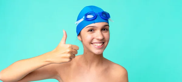 年轻漂亮的女人感到自豪 带着泳镜竖起大拇指 面带微笑 — 图库照片