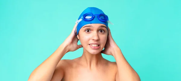 年轻漂亮的女人感到紧张 焦虑或害怕 双手放在头上 戴着泳镜 — 图库照片