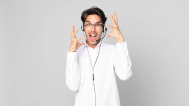 Genç İspanyol adam ellerini havaya kaldırarak çığlık atıyor. tele pazarlamacı kavramı