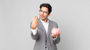 Genç İspanyol adam kapiş ya da para hareketi yapıyor. Sana ödemeni ve kumbarayı tutmanı söylüyor.