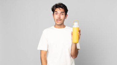 Kafası karışmış ve kahve termosuyla kafası karışmış genç İspanyol bir adam.