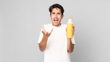 Genç İspanyol bir adam kahve termosuyla çaresiz, sinirli ve stresli görünüyor.