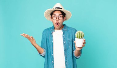 Genç İspanyol adam şaşırdı, şaşırdı ve hayrete düştü. İnanılmaz bir sürprizle ve elinde bir kaktüsle.