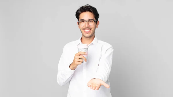 フレンドリーでオファーに満面の笑みを浮かべてコンセプトを示しテイクアウトコーヒーを持っている若いヒスパニック系の男 — ストック写真