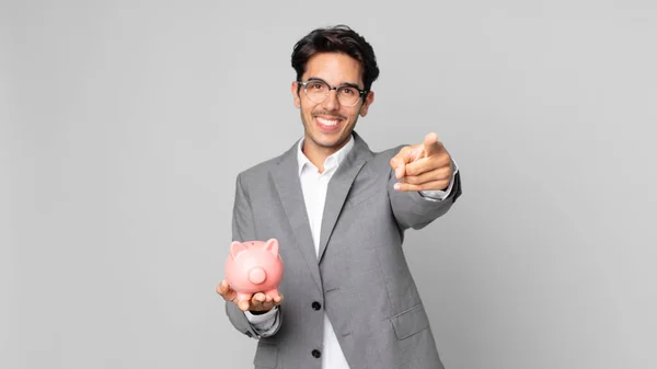 Young Hispanic Man Pointing Camera Choosing You Holding Piggy Bank — Stock Photo, Image