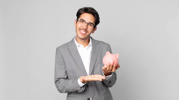 若いヒスパニック系の男は陽気に笑顔で 幸せを感じ 概念を示し 貯金箱を持っている — ストック写真