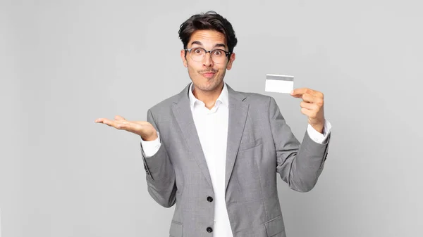 Jovem Hispânico Sentindo Intrigado Confuso Duvidar Segurando Cartão Crédito — Fotografia de Stock