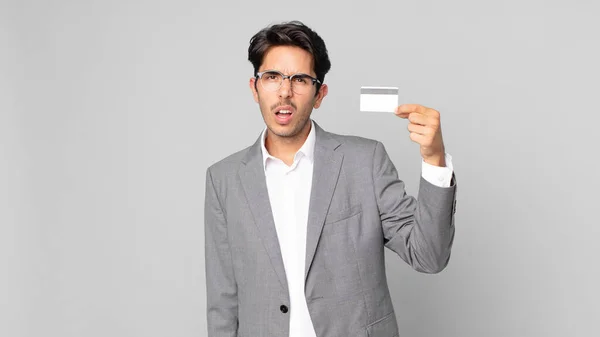 Joven Hispano Sintiéndose Desconcertado Confundido Sosteniendo Una Tarjeta Crédito — Foto de Stock