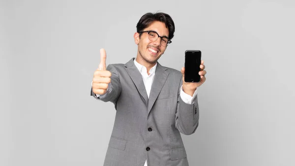 Young Hispanic Man Feeling Proud Smiling Positively Thumbs Holding Smartphone — Stock Photo, Image