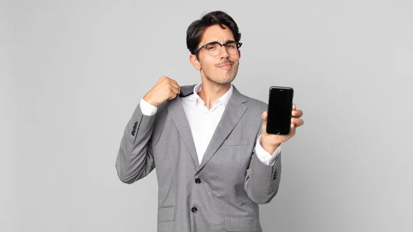 Young Hispanic Man Looking Arrogant Successful Positive Proud Holding Smartphone — Stock Photo, Image