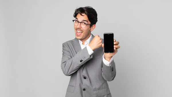 Jovem Hispânico Homem Sentindo Feliz Enfrentando Desafio Celebrando Segurando Smartphone — Fotografia de Stock