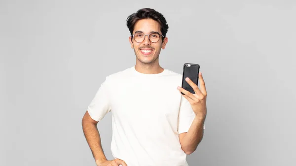 Joven Hispano Sonriendo Felizmente Con Una Mano Cadera Confiado Sosteniendo —  Fotos de Stock