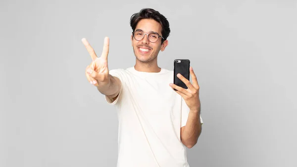 Jovem Hispânico Homem Sorrindo Olhando Feliz Gesticulando Vitória Paz Segurando — Fotografia de Stock