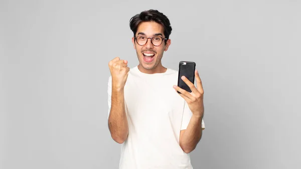 Nuori Latino Mies Tunne Järkyttynyt Nauraa Juhlii Menestystä Tilalla Älypuhelin — kuvapankkivalokuva