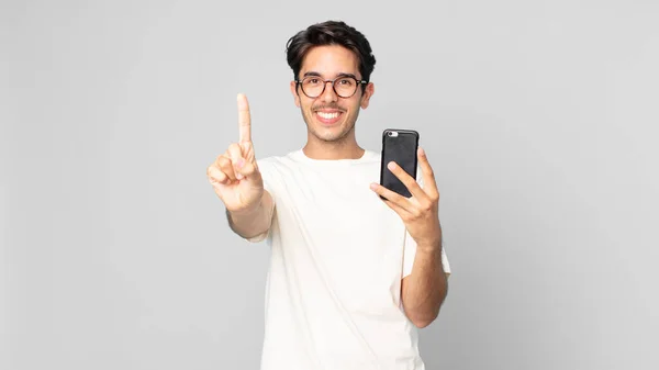 Junger Hispanischer Mann Lächelt Freundlich Zeigt Nummer Eins Und Hält — Stockfoto