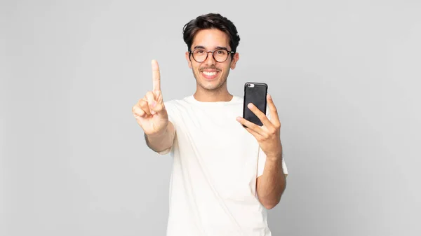 Joven Hombre Hispano Sonriendo Buscando Amigable Mostrando Número Uno Sosteniendo —  Fotos de Stock