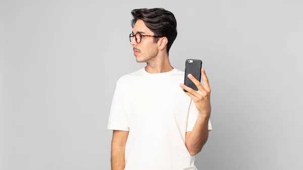 Young Hispanic Man Profile View Thinking Imagining Daydreaming Holding Smartphone — Stock Photo, Image