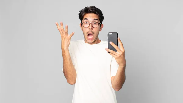 Jovem Hispânico Homem Gritando Com Mãos Segurando Smartphone — Fotografia de Stock