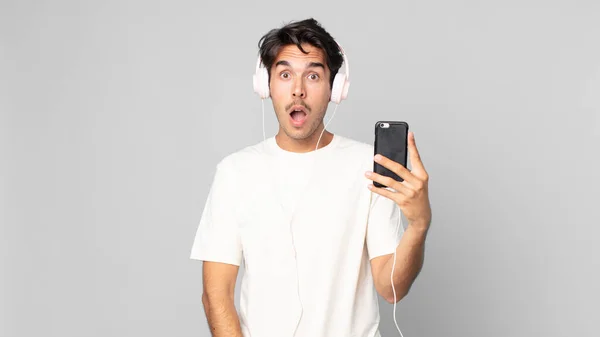 Mladý Hispánec Vypadá Velmi Šokován Nebo Překvapen Sluchátky Smartphonem — Stock fotografie
