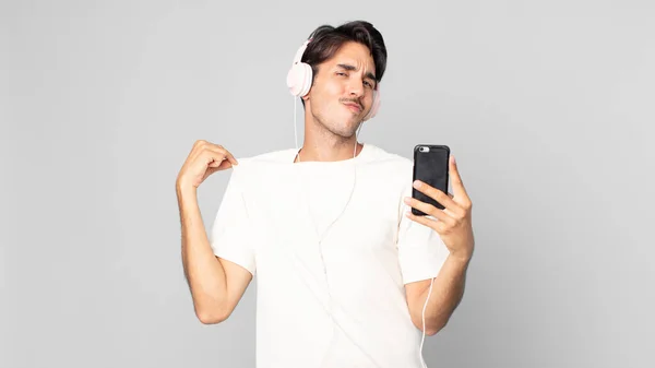 Młody Hiszpan Wygląda Arogancki Udany Pozytywny Dumny Słuchawek Smartfona — Zdjęcie stockowe
