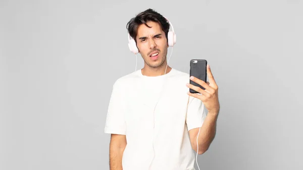 Young Hispanic Man Feeling Puzzled Confused Headphones Smartphone — Stock Photo, Image