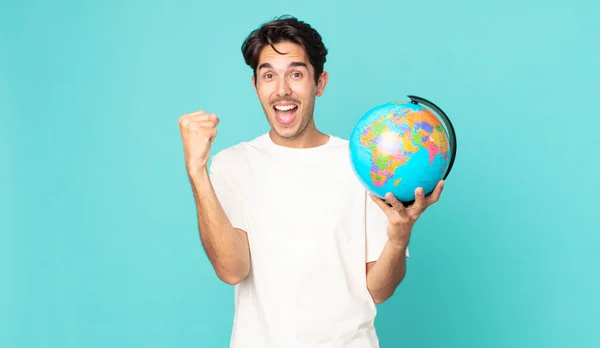 Jovem Hispânico Sentindo Chocado Rindo Celebrando Sucesso Segurando Mapa Globo — Fotografia de Stock