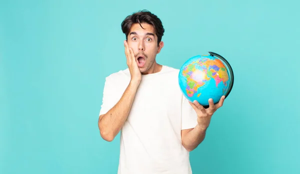Jovem Hispânico Homem Sentindo Chocado Assustado Segurando Mapa Mundo Globo — Fotografia de Stock