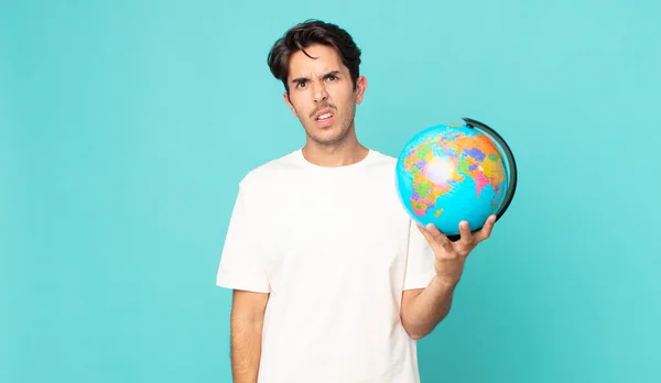 Jovem Hispânico Homem Sentindo Intrigado Confuso Segurando Mapa Mundo Globo — Fotografia de Stock