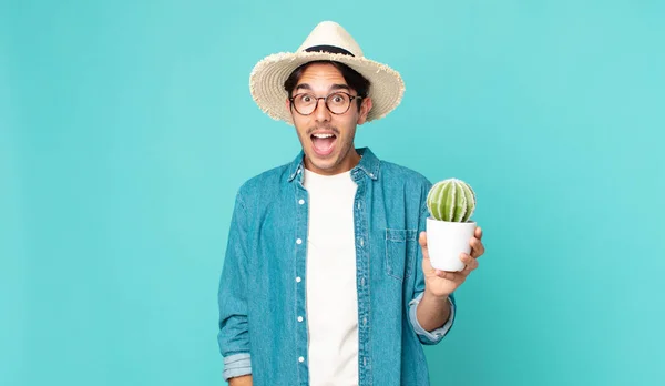 Jonge Spaanse Man Kijkt Erg Geschokt Verrast Houdt Een Cactus — Stockfoto