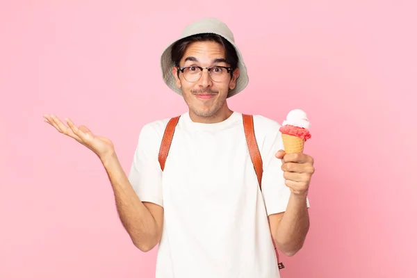若いヒスパニック系の男は困惑し混乱し疑いアイスクリームを持っています — ストック写真
