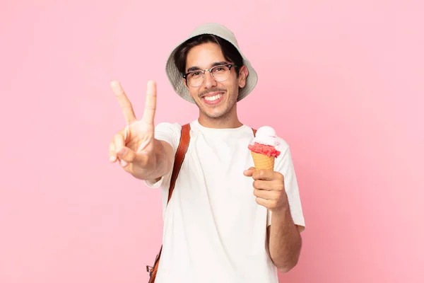若いヒスパニック系の男は笑顔と幸せそうな顔勝利や平和をジェスチャーやアイスクリームを保持 — ストック写真