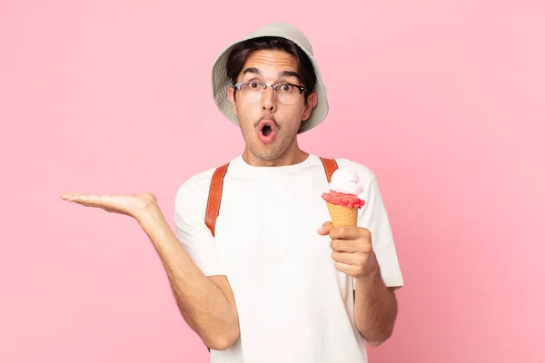 Joven Hispano Mirando Sorprendido Sorprendido Con Mandíbula Caída Sosteniendo Objeto —  Fotos de Stock