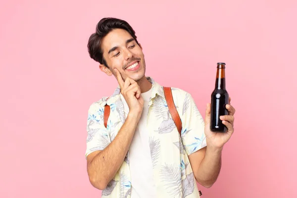 Jovem Hispânico Sorrindo Feliz Sonhando Acordado Duvidando Segurando Uma Garrafa — Fotografia de Stock