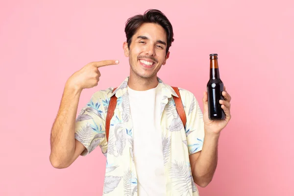 若いヒスパニック系の男は自信を持って広い笑顔を指摘し ビールのボトルを保持笑顔 — ストック写真