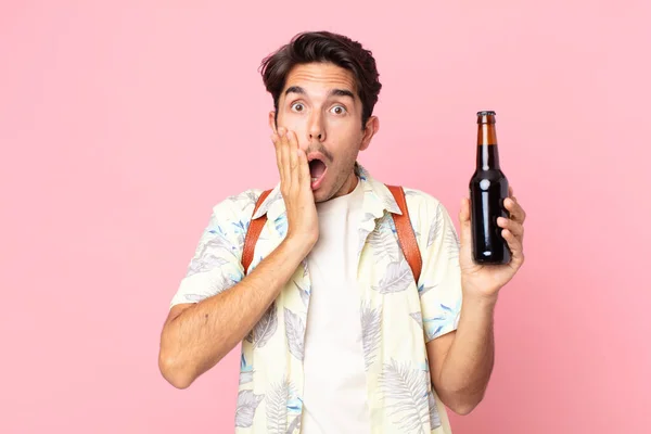 Jovem Hispânico Sentindo Chocado Assustado Segurando Uma Garrafa Cerveja — Fotografia de Stock